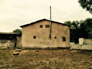 house wall with thin chimney on side