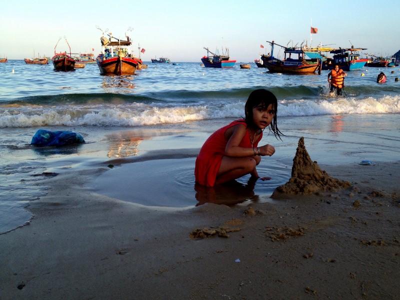 κοριτσάκι από το βιετνάμ χτίζει κάστρο από άμμο στο χωριό dai lanh