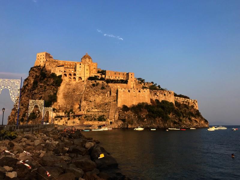 Castle on little island connected with noarrow bridge to ischia island in the gulf of naples