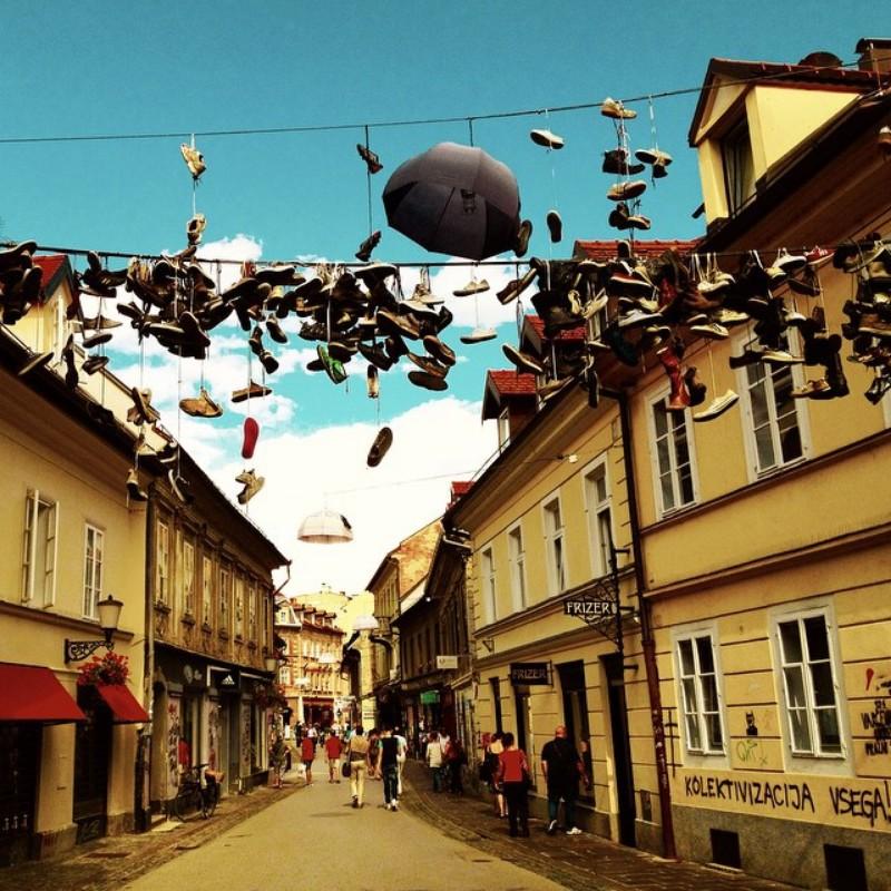 shoes and umbrella hung on cables over ljubljana street