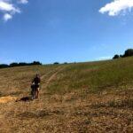 Pushing bicycle down a grassy hill near cattolica, italy
