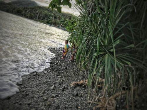 little filipino kids hiding behind bush