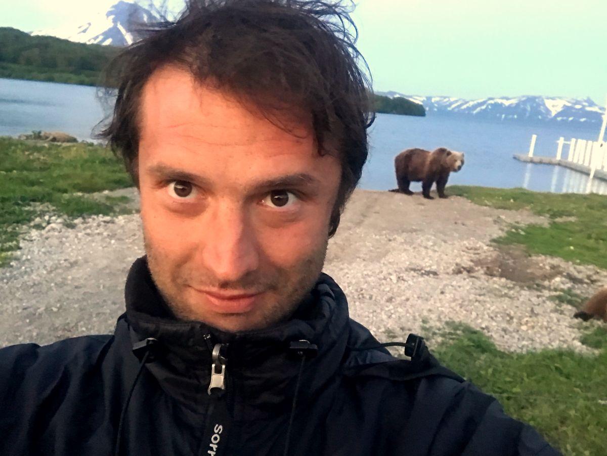 man taking a selfie with a bear at kurile lake national park in kamchatka