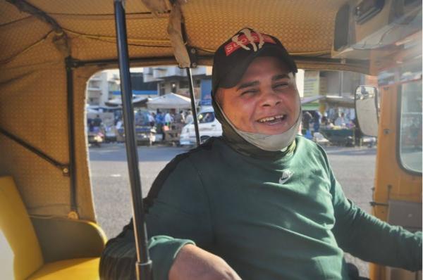 Iraqi tuk-tuk driver smiling for a photo