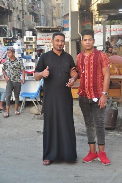 Traditionally dressed Iraqi man with modernly dressed boy
