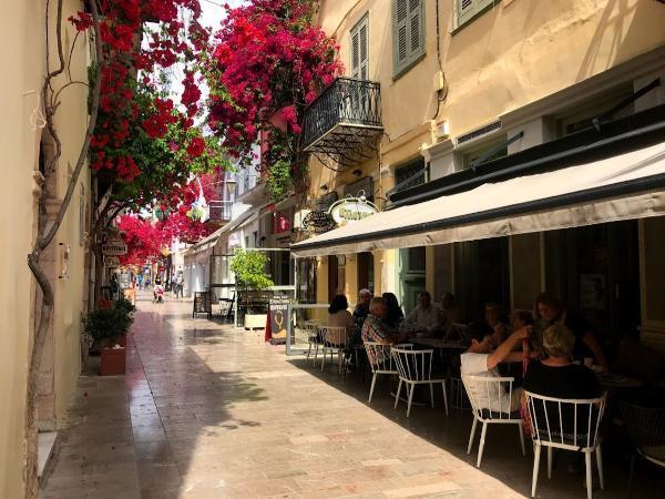 Red Bougainvillea flowers over narrow streets of Nafplio