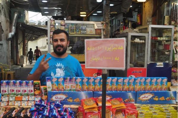 man selling juices and snacks on stall in Sulaymaniyah