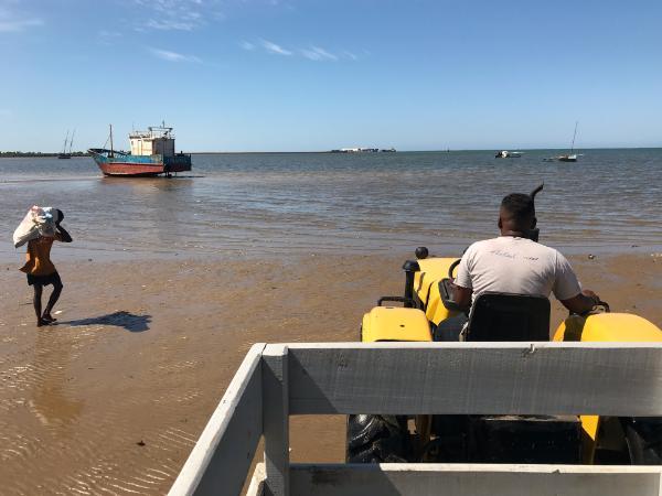 Tractor towing passengers to boat past sandbar anakao tulear