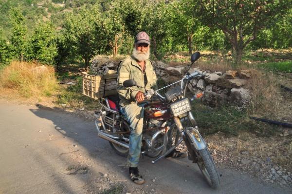 lebanese man with a beard riding a motorbike in afqa village
