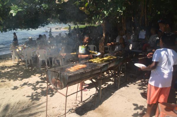 mauritians grilling meat and seafood at makeshift beach restaurant in cap malheureux