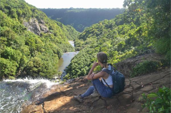 girl enjoying the view from ledge above the sixth of the seven waterfalls of tamarind in mauritius