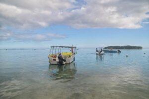 boat floating on calm waters of blue bay in mauritius