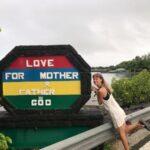 girl posing beside a positive message sign in mahebourg, mauritius