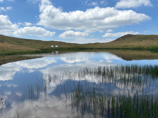 The Dragon Lake of mount smolikas reflecting the blue sky and cumulus clouds