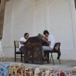 artisans working on traditional plates inside fort of bukhara, uzbekistan