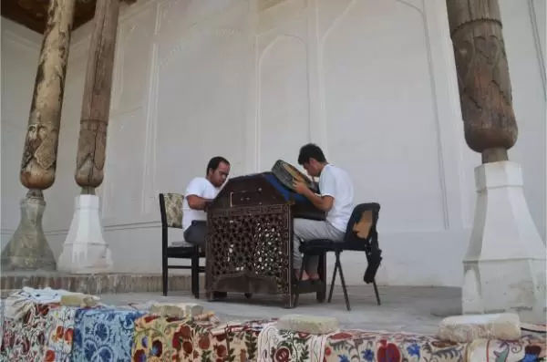 artisans working on traditional plates inside fort of bukhara, uzbekistan