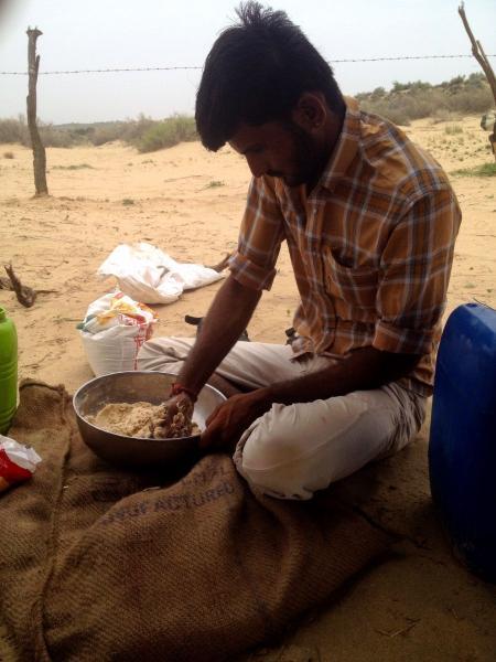 an indian man preparing dough for chapati in thar desert 