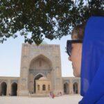 girl with blue scarf in the yard of po i kalyan mosque in bukhara, uzbekistan