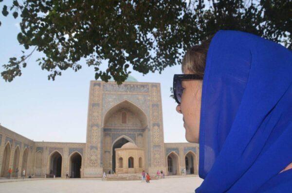 girl with blue scarf in the yard of po i kalyan mosque in bukhara, uzbekistan