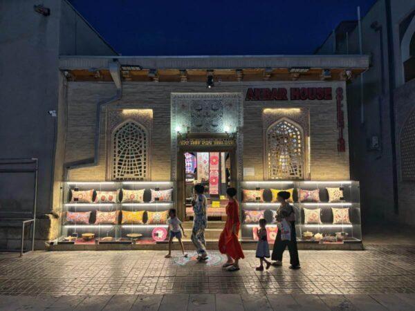 Brightly lit souvenir shop in Bakhovaddin Naqshband Street at night