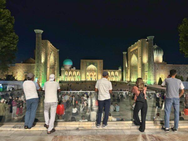 people looking at registan square at night