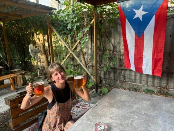 drinking beer below a puerto rican flag in in somewherebistro bar in bishkek