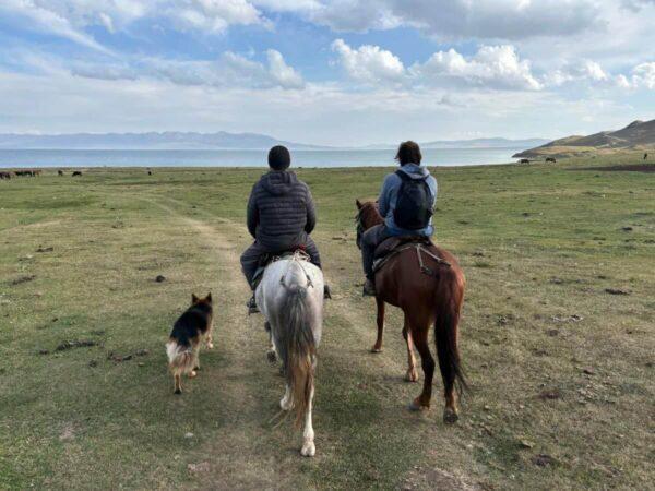 Riding horses by Son-Kul lake in kyrgyzstan