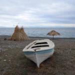 photo of a beached boat on a sandy beach of vasilika village on euboea island, greece