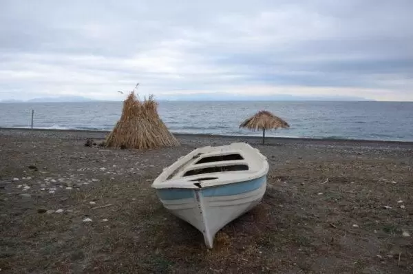 photo of a beached boat on a sandy beach of vasilika village on euboea island, greece