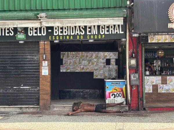 drunk guy collapsed in the morning in front of a closed bar in rio das ostras, brazil